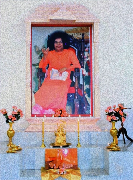 The altar at the Sri Sathya Sai Baba Centre of Middlefield, with a portrait of Bhagawan Sri Sathya Sai Baba framed in white and gold